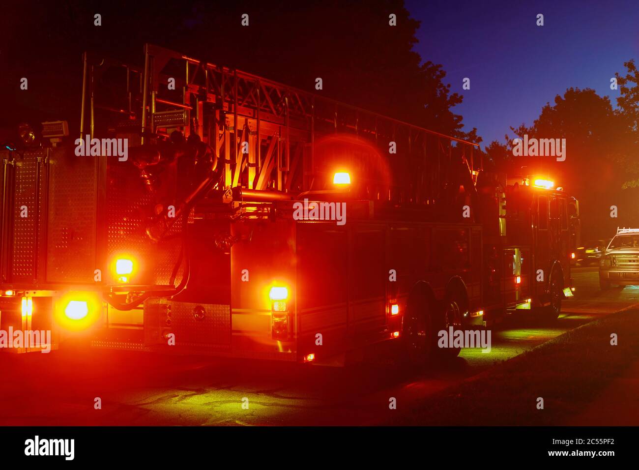 Fire truck with flashing red lights of a fire engine night time in dusk