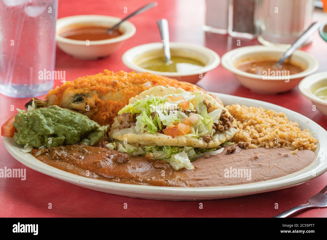 Mexican delicious taco with guacamole rice and salsas in a plate Stock Photo