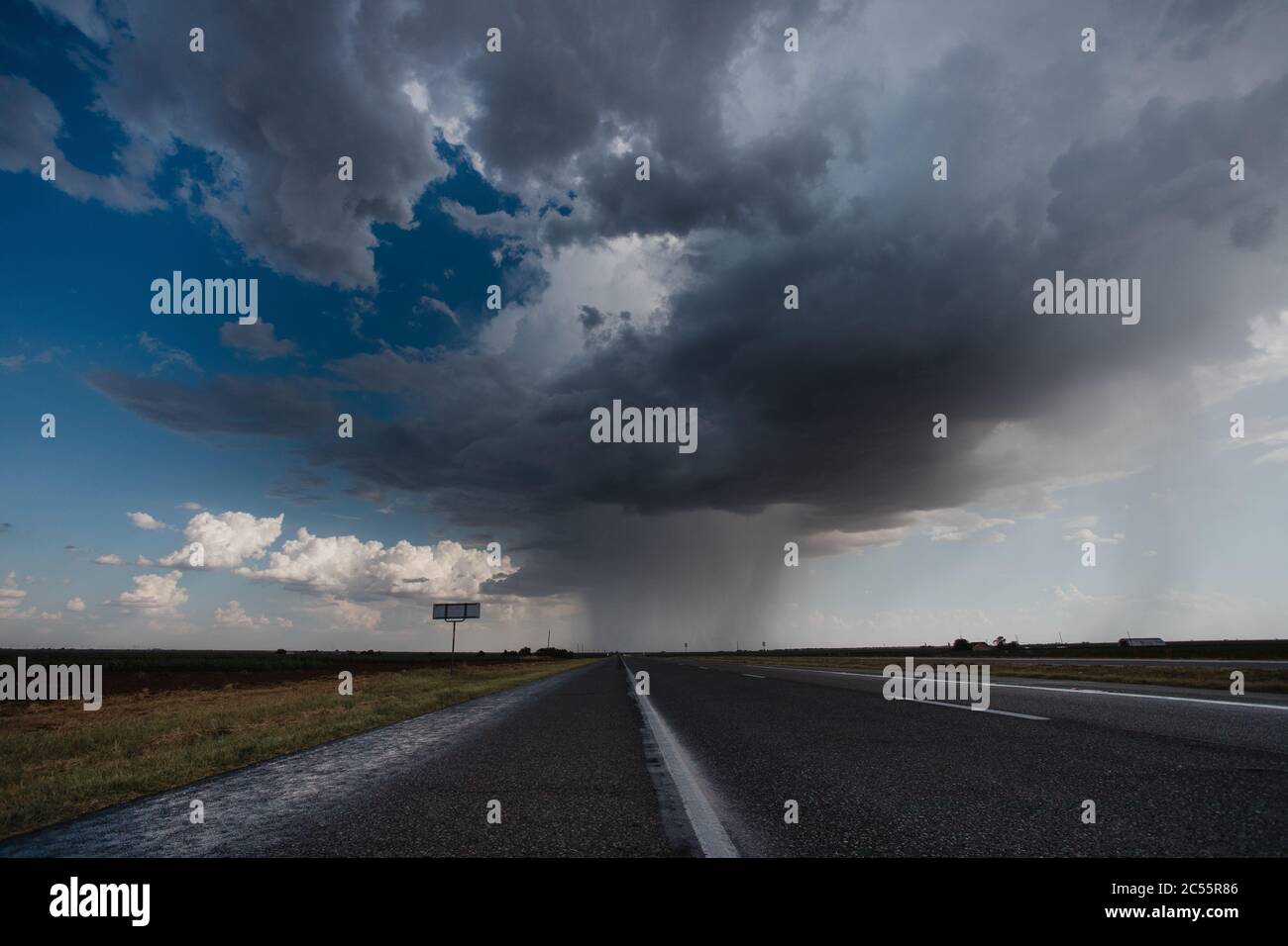 Long asphalt road under the cloudy rainy sky Stock Photo - Alamy
