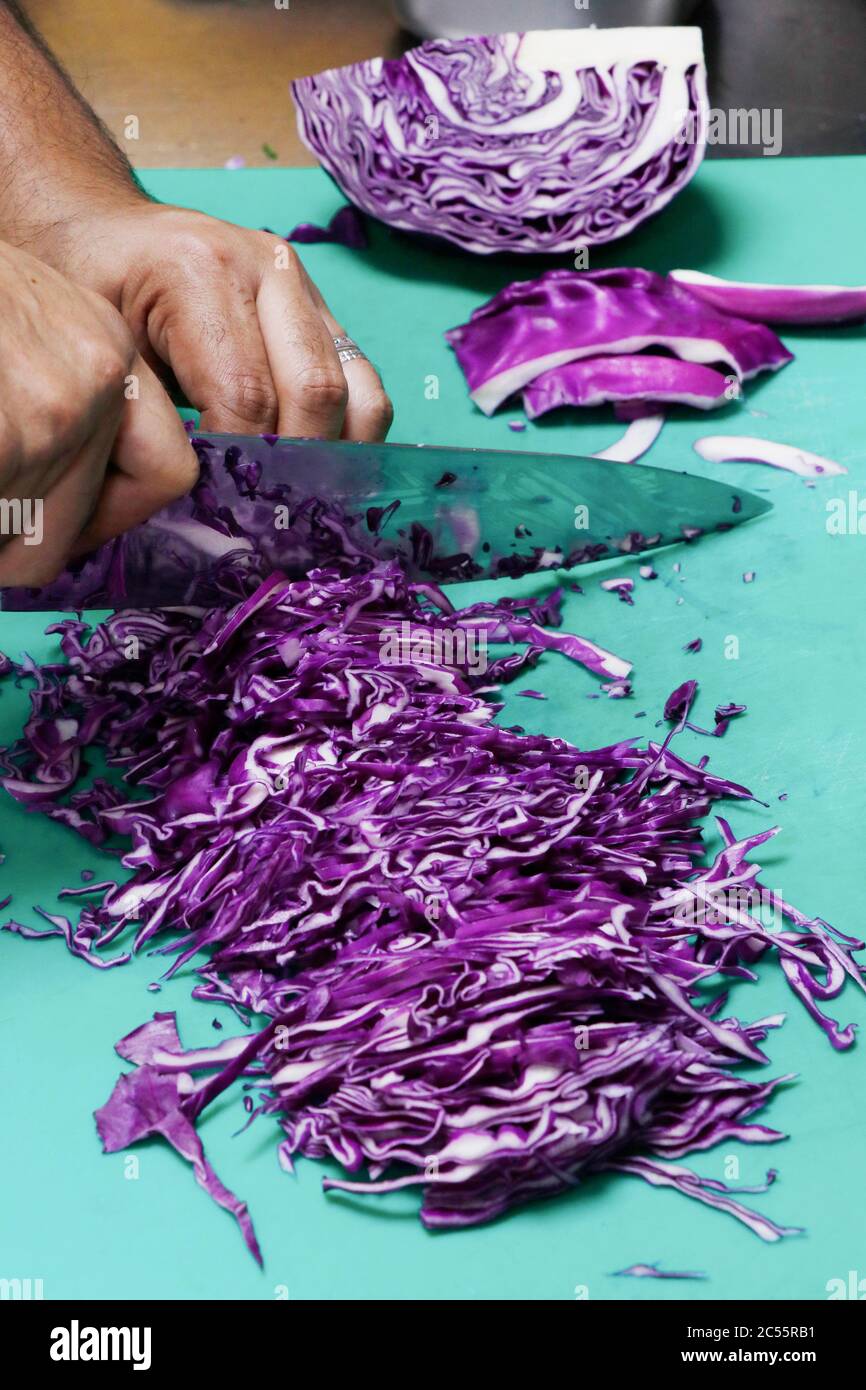 chef cutting vegetables on a green cutting board Stock Photo