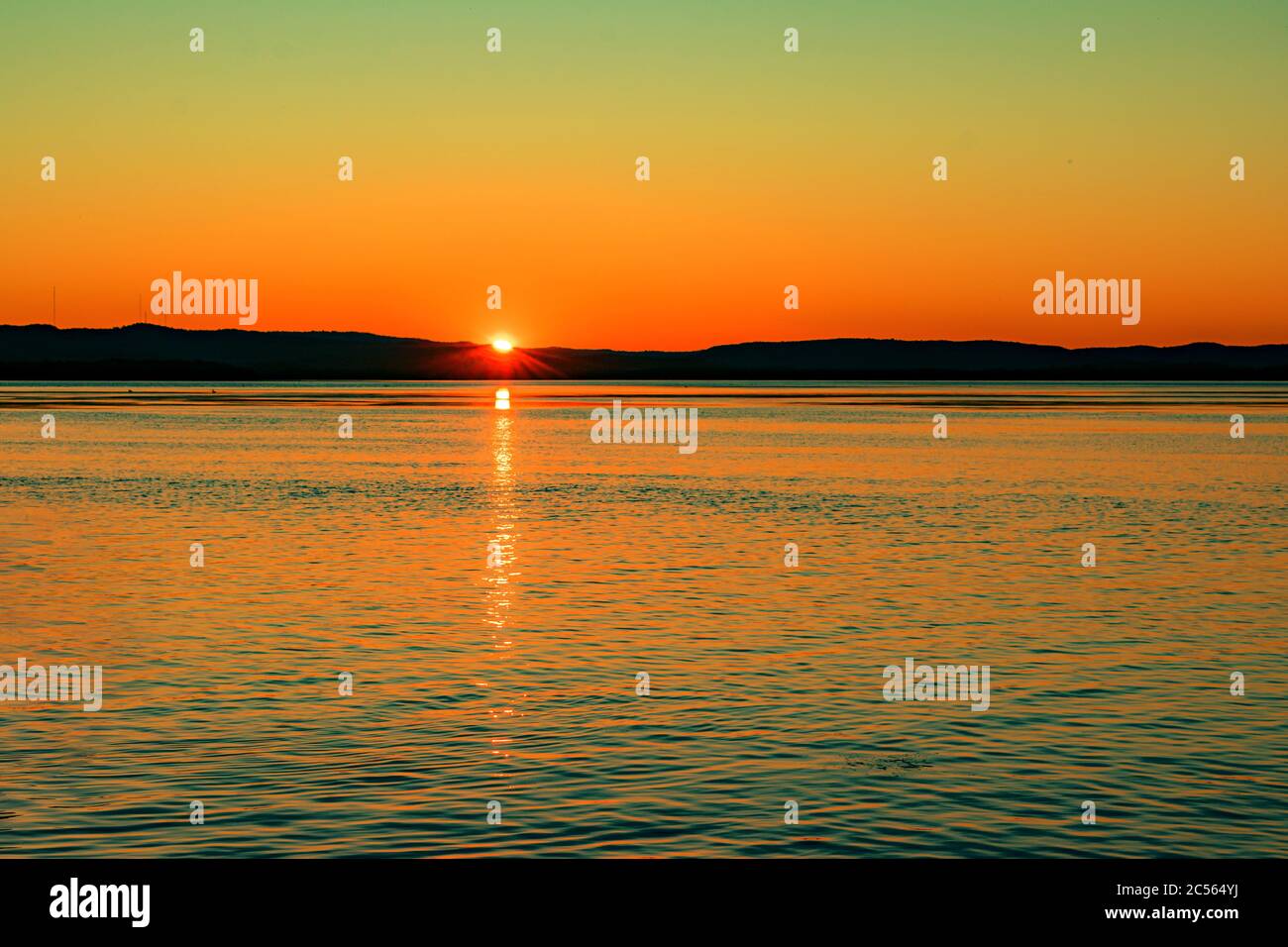 Breathtaking scenery of the sunset sky reflecting in the peaceful sea ...