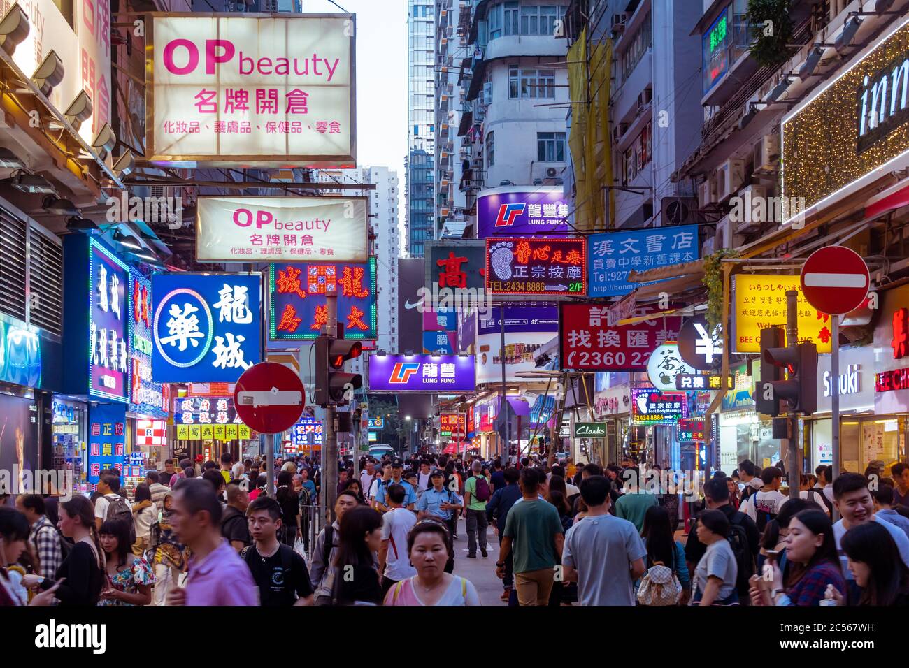 Neon storefront signs illuminate the crowded streets of the famous Mong