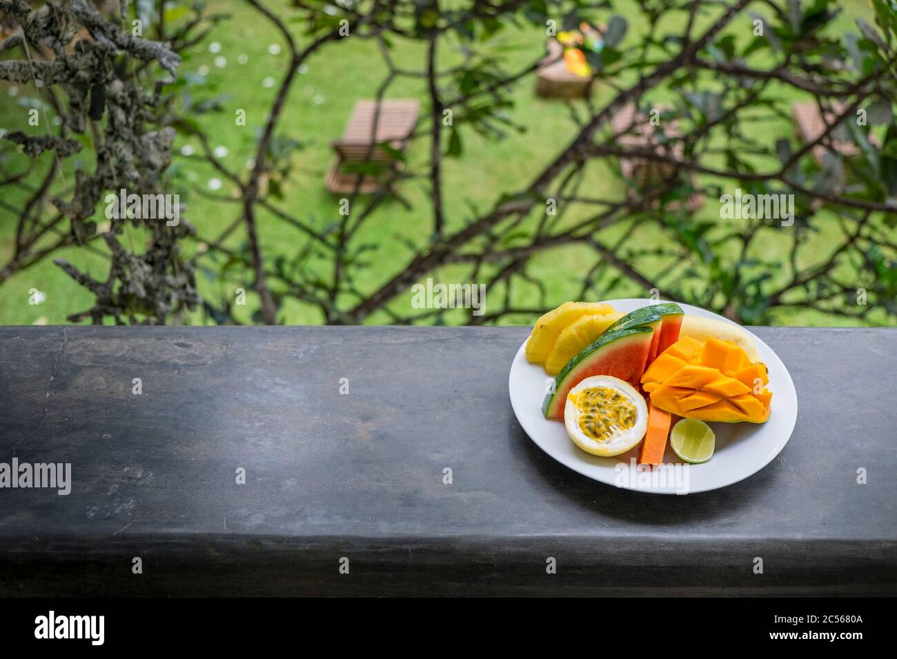 colorful fruit plate on the balcony overlooking the garden Stock Photo