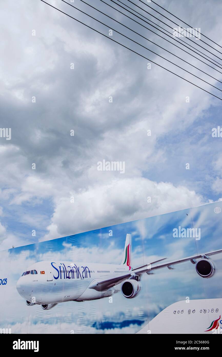 An airline billboard with an airplane against a cloudy sky Stock Photo
