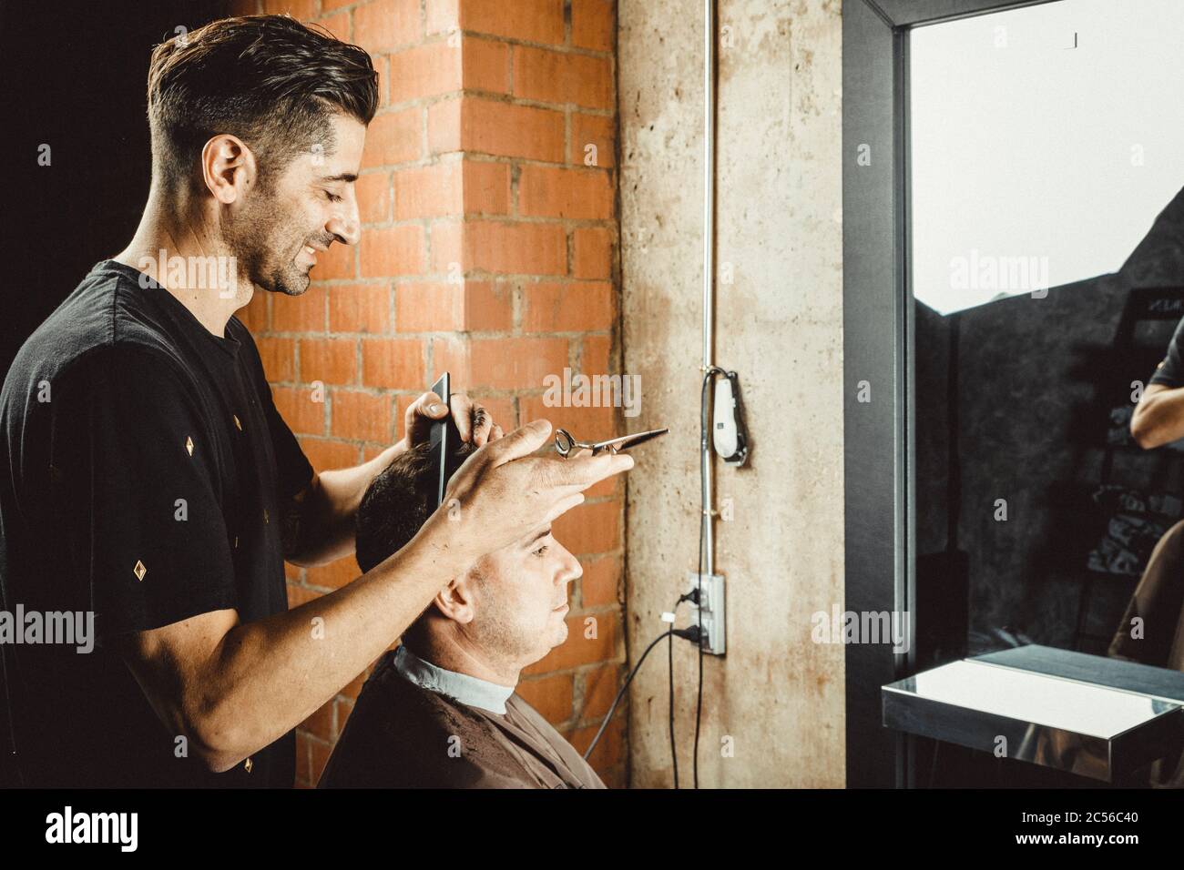 hairdresser and beautician working in her hair salon Stock Photo