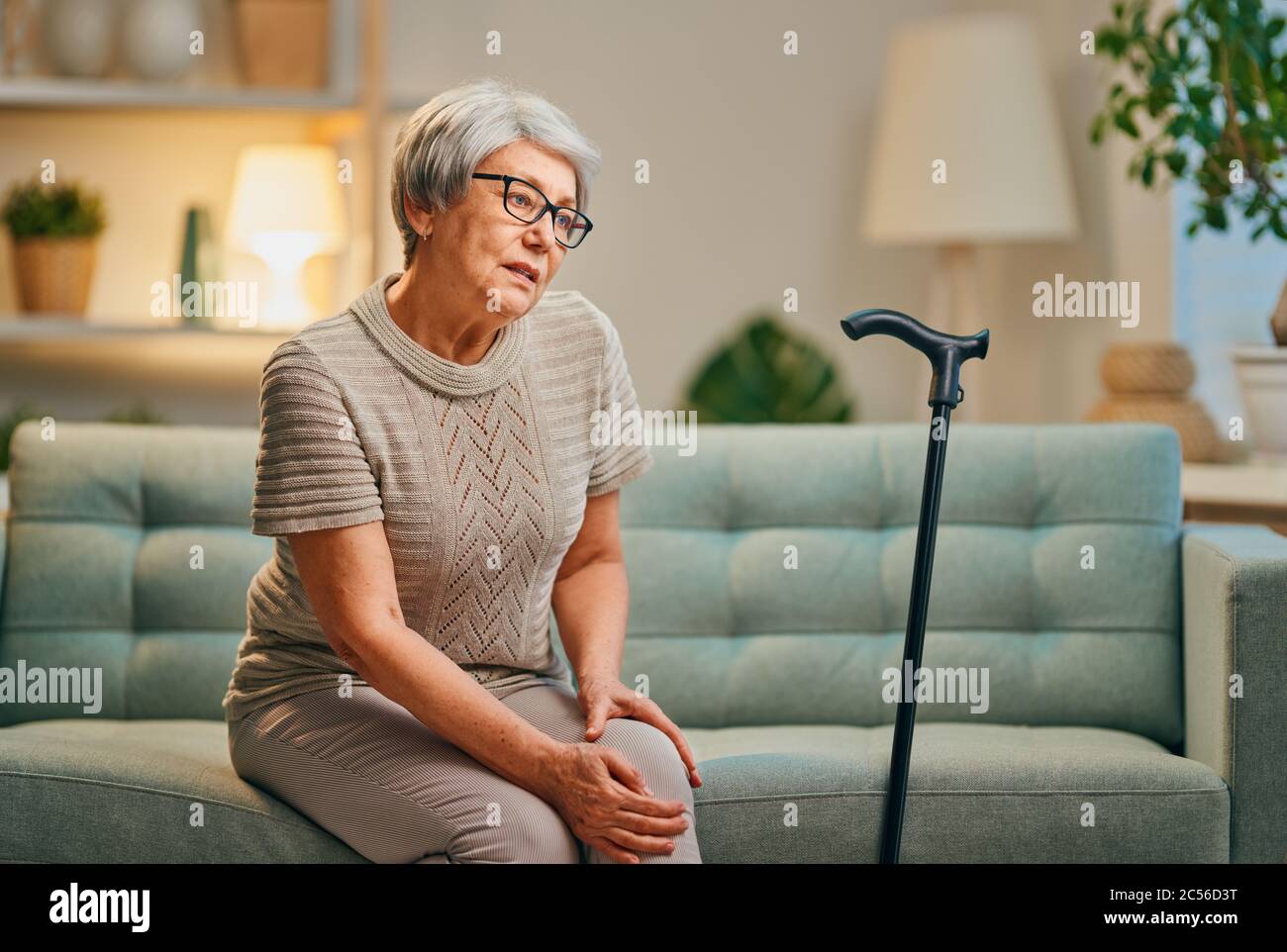 Senior woman with cane. Feeling unwell and pain in the knee Stock Photo
