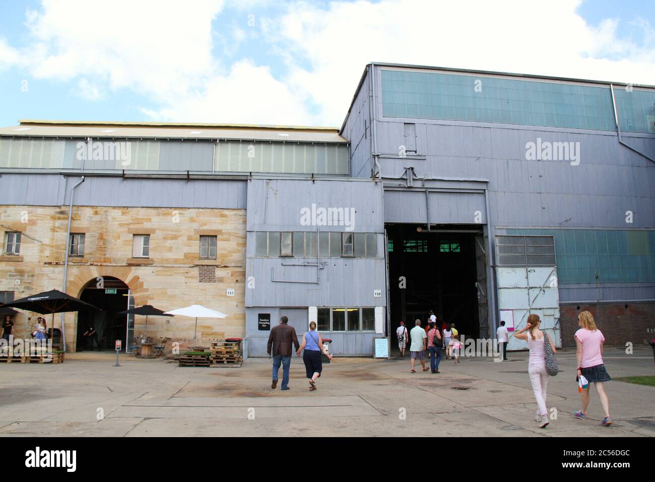 People enter the beginning of the Industrial Precinct on the Lower Island of Cockatoo Island during the 19th Biennale of Sydney. Stock Photo