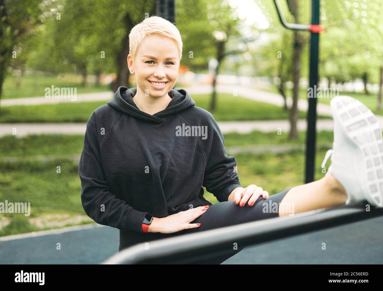 Attractive fit young woman in sport wear stretching on street workout area Stock Photo