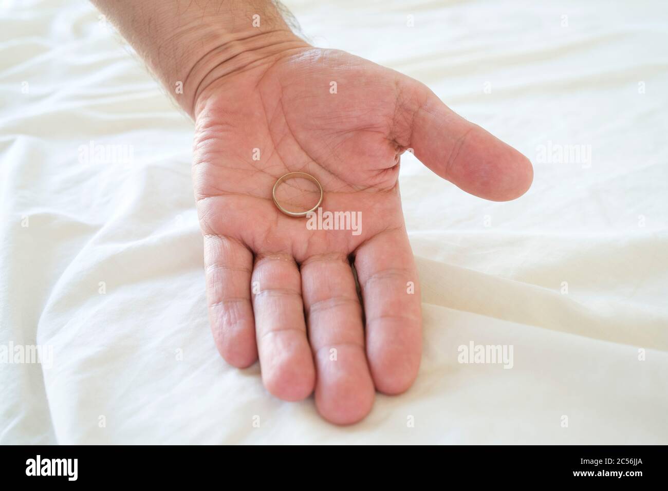 Hand of a man holding a wedding ring Stock Photo
