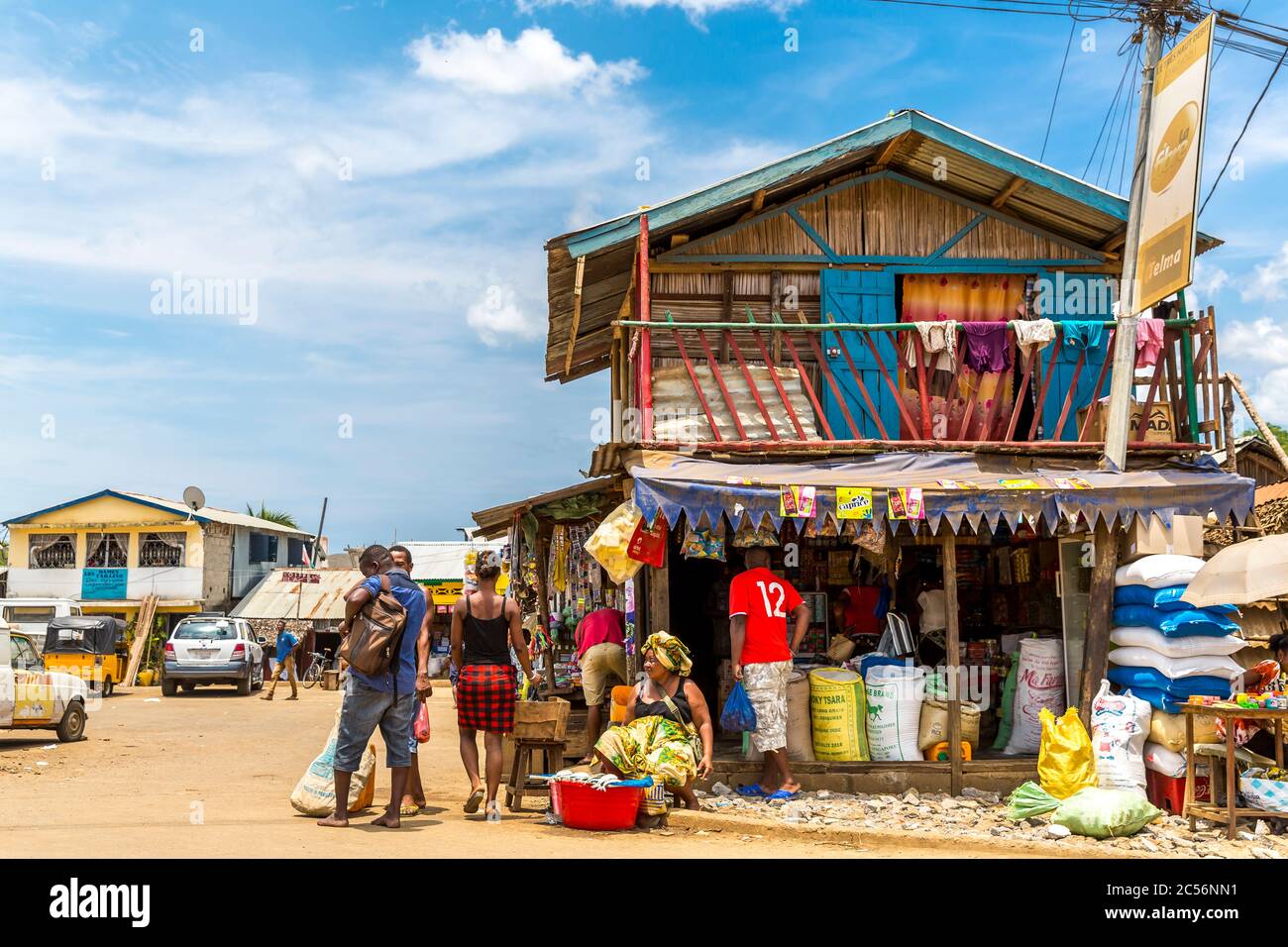 Fish seller in front of a mix shop, street scene in Andoany, Hell-Ville, Nosy Bé Island, Madagascar, Africa, Indian Ocean Stock Photo
