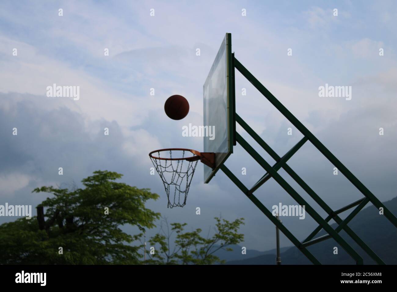 Basketball going into basketball hoop Stock Photo Alamy