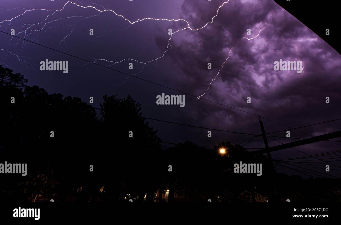 Lightning storm over the city in purple light Stock Photo - Alamy