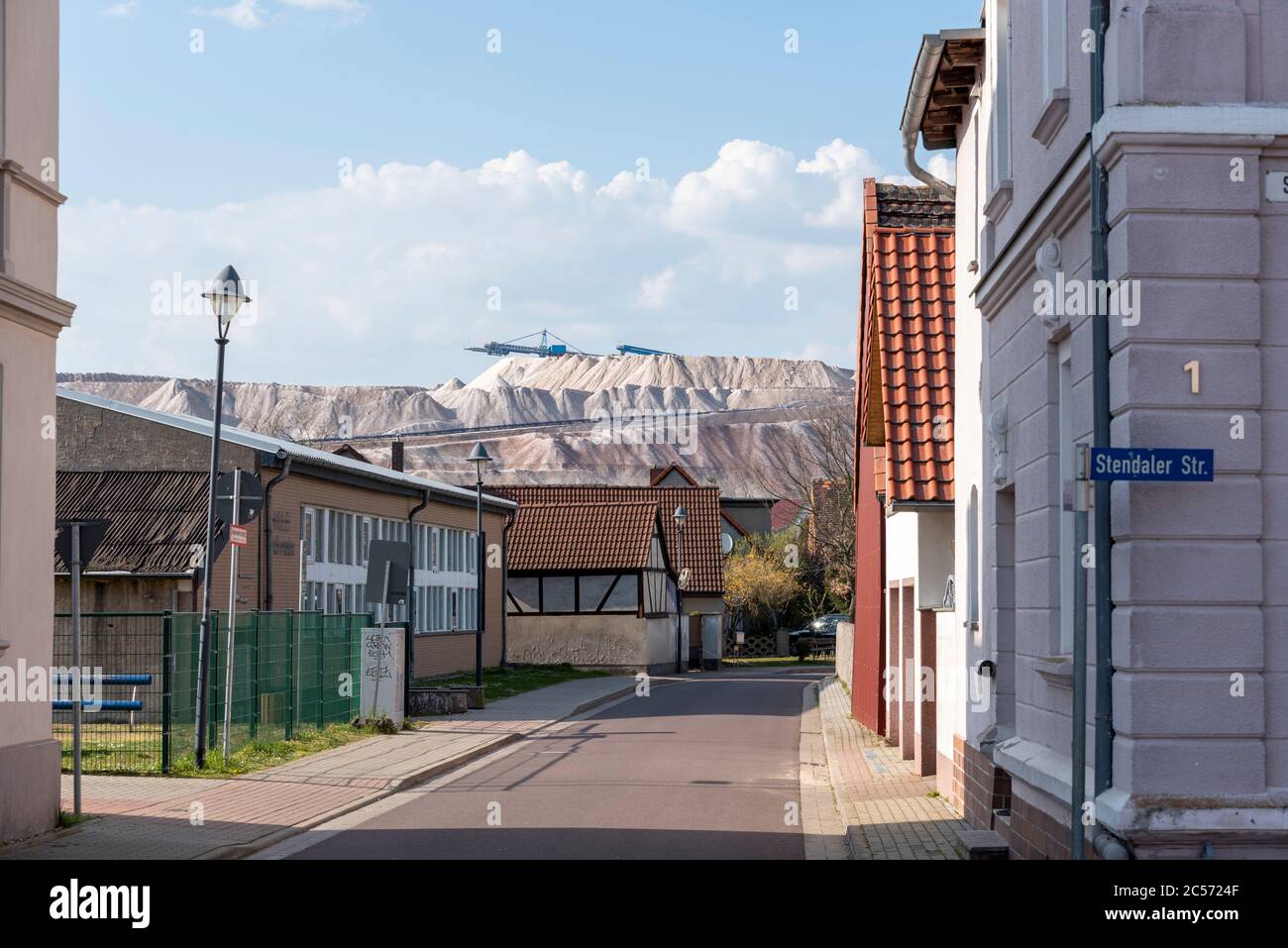 Germany, Saxony-Anhalt, Loitsche: Behind half-timbered houses, the tailings dump of the Zielitz potash works. K&S Kali GmbH is one of the leading salt Stock Photo