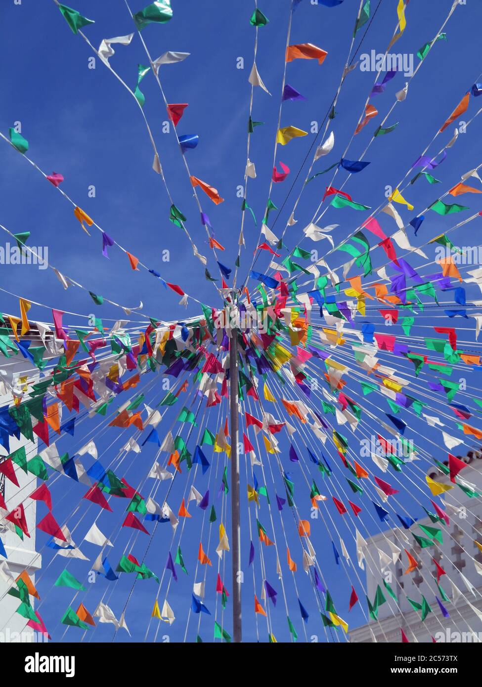Vibrant multicolored flags against sunny blue sky Stock Photo