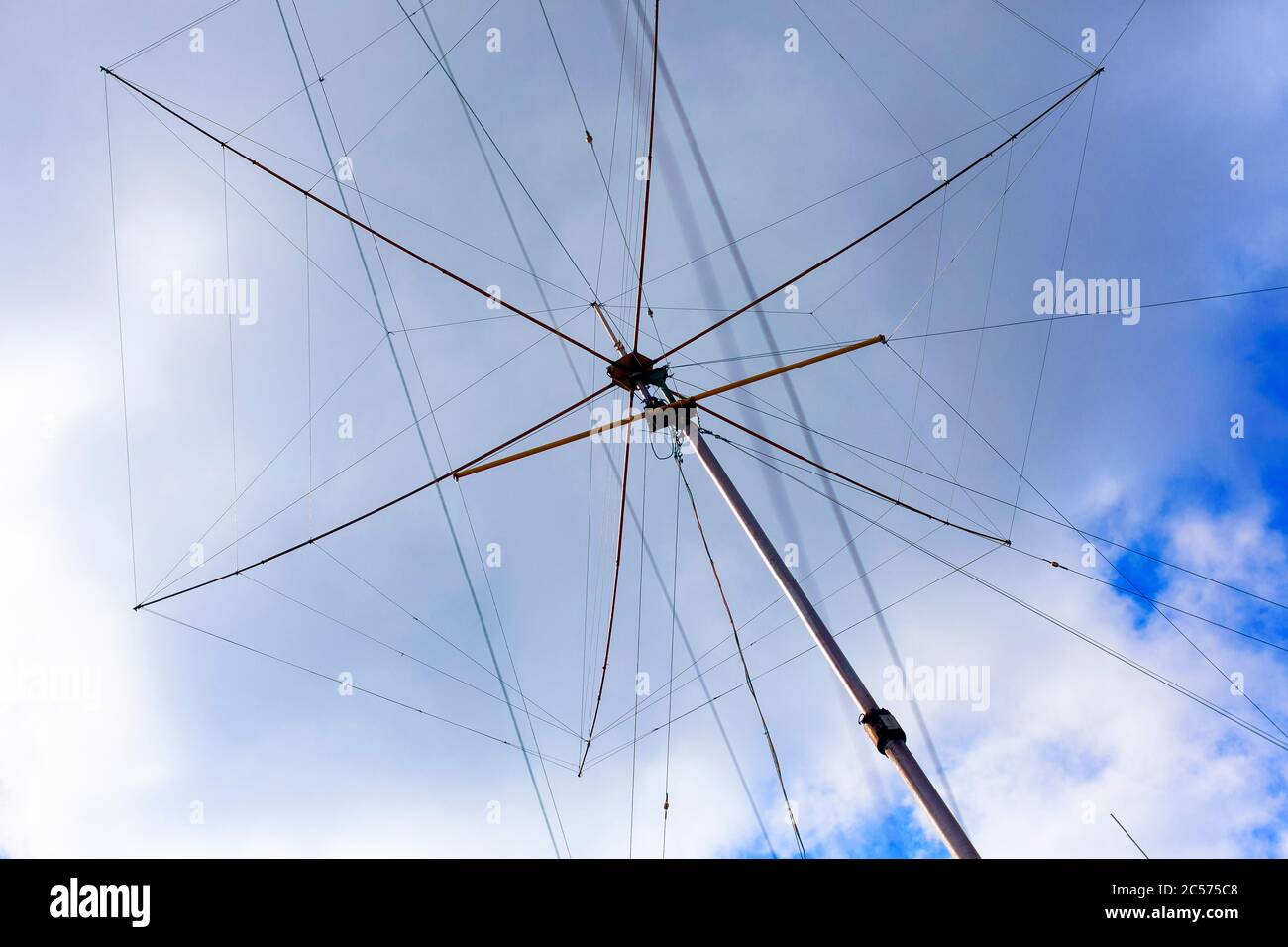Tall Ham radio (amateur radio) antenna against cloudy sky. Stock Photo
