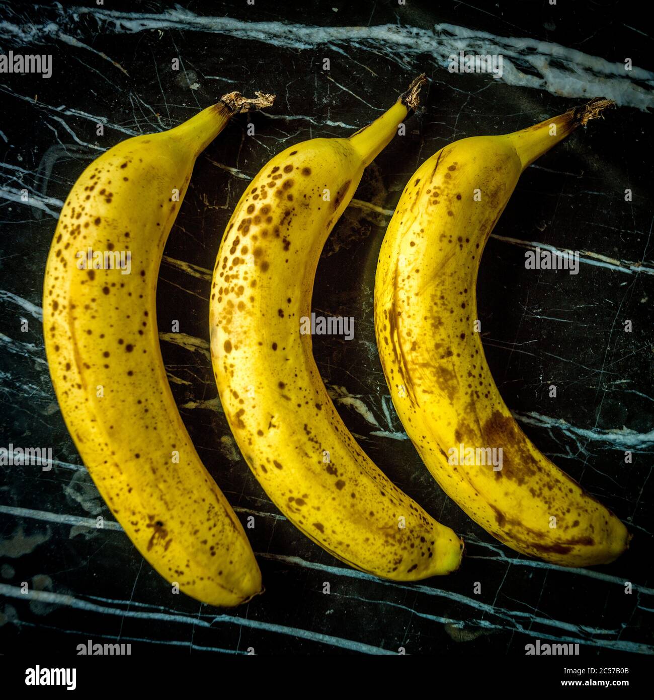 Three bananas on a marble table Stock Photo