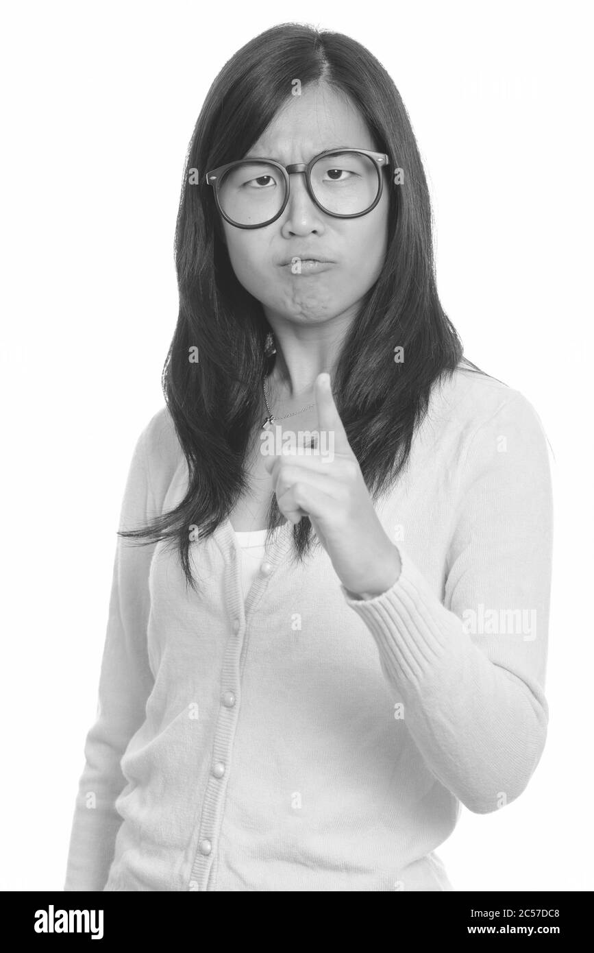 Young beautiful Asian woman looking angry while pointing finger Stock Photo