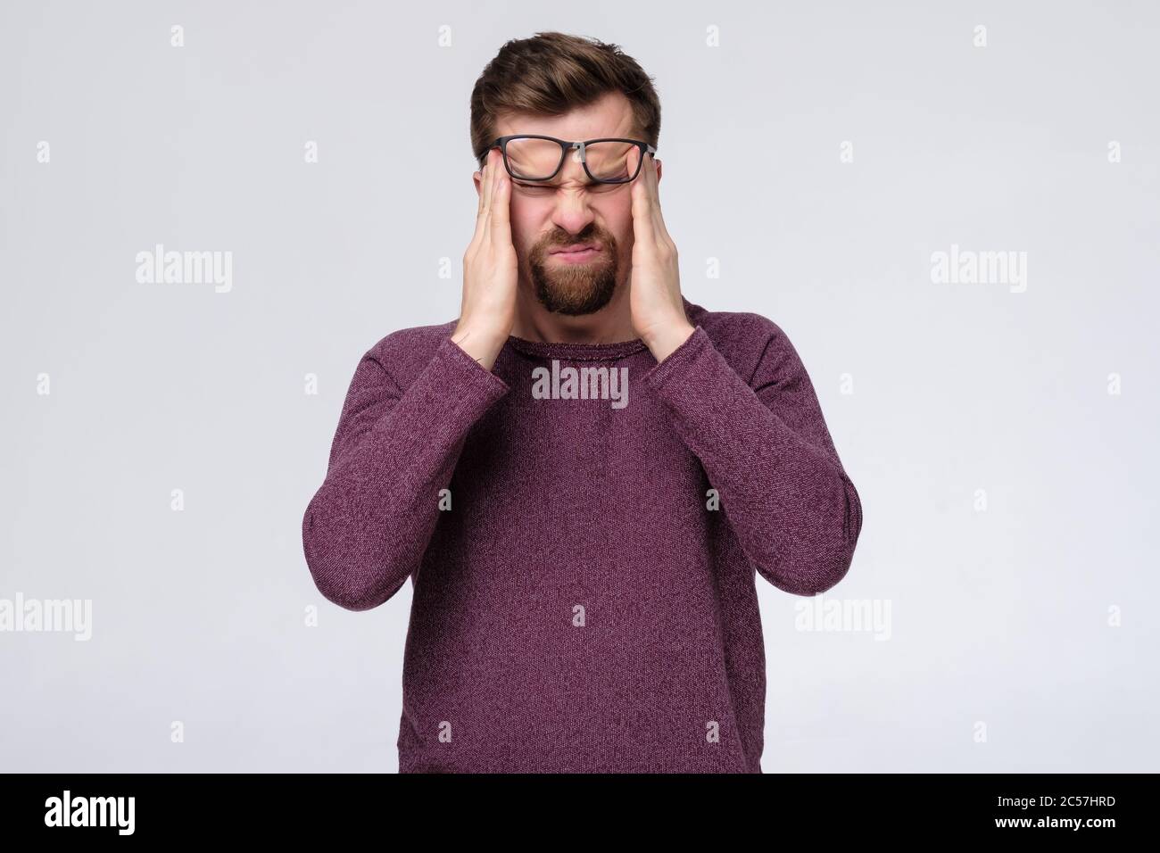 Man having headache pressing on his temples. Stock Photo