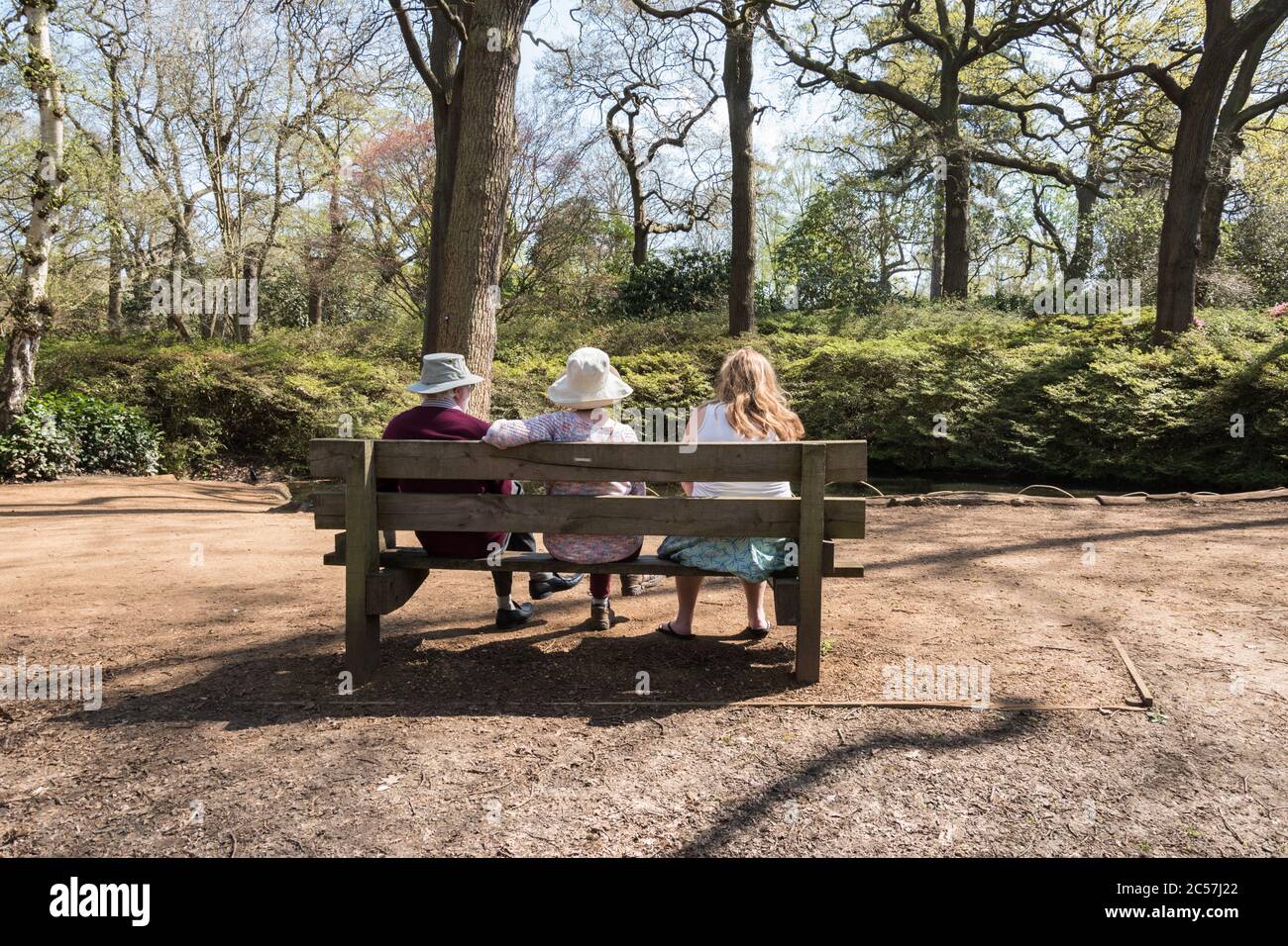 An elderly family sitting on a park bench in London, UK Stock Photo