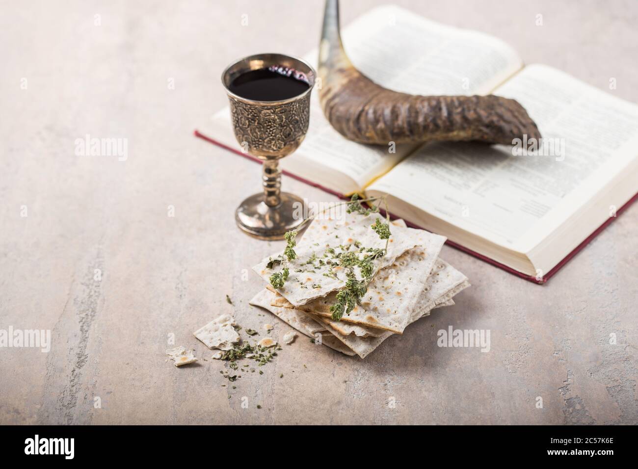 Pack of matzah or matza, Passover Haggadah and Kosher red wine, shofar-horn on a concrete background. Stock Photo