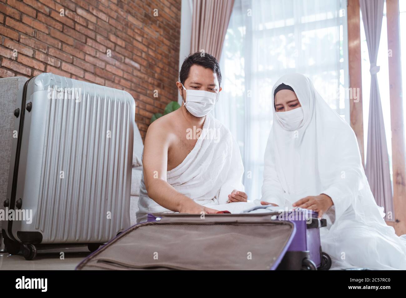 muslim pilgrims wife and husband packing for Hajj and umrah Stock Photo