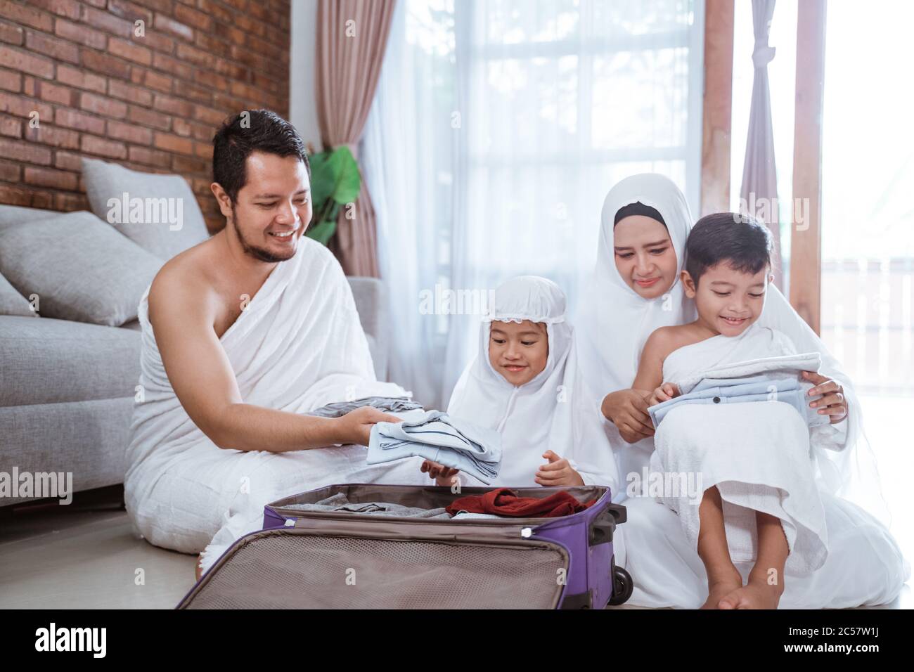muslim family hajj and umrah pilgrim with children packing at home 