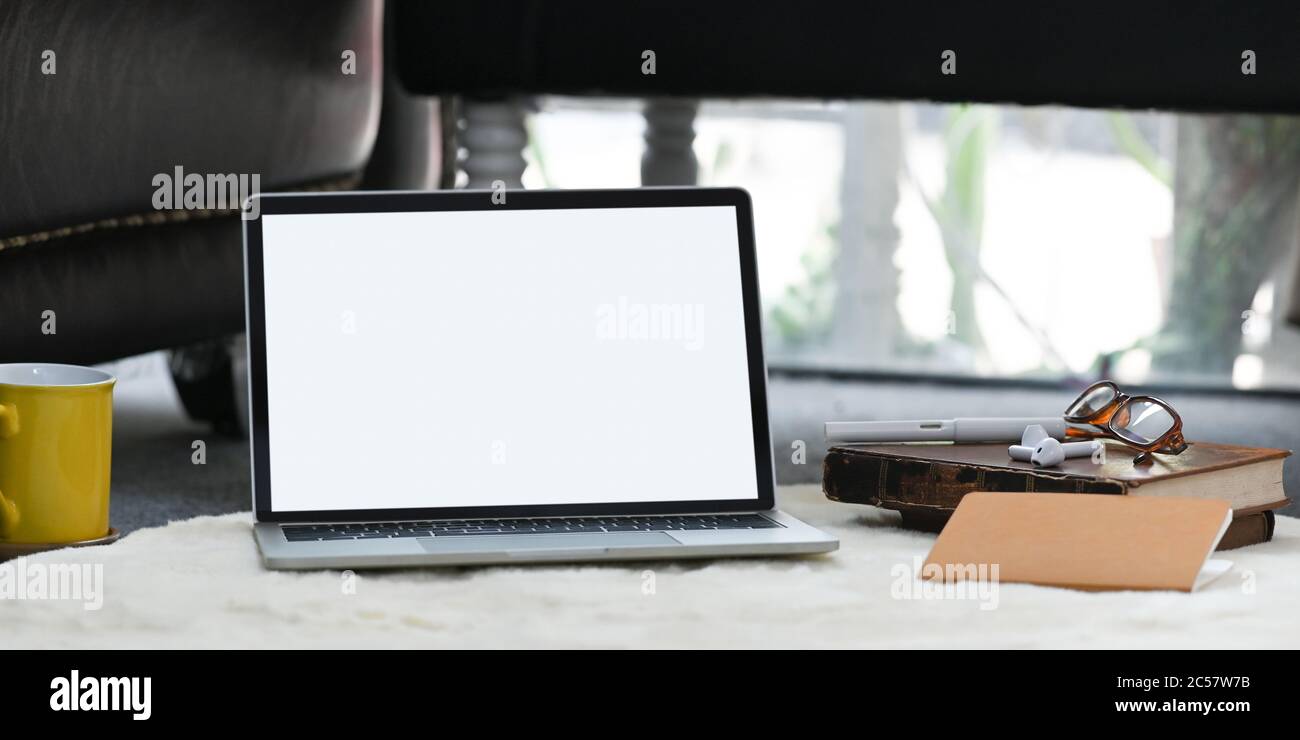 A white blank screen computer laptop is putting on the white furry