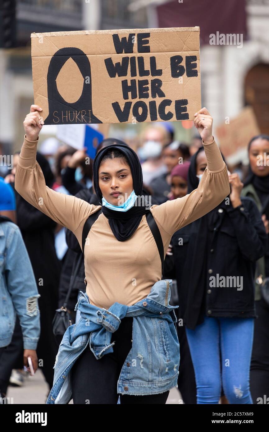 A woman holds a protest sign above her head at a Black Lives Matter demonstration, London, 27 June 2020 Stock Photo