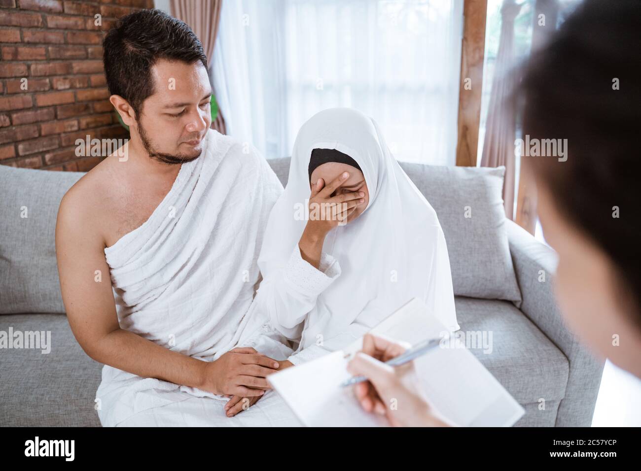 sad muslim woman and husband being cancel to travel for hajj Stock Photo
