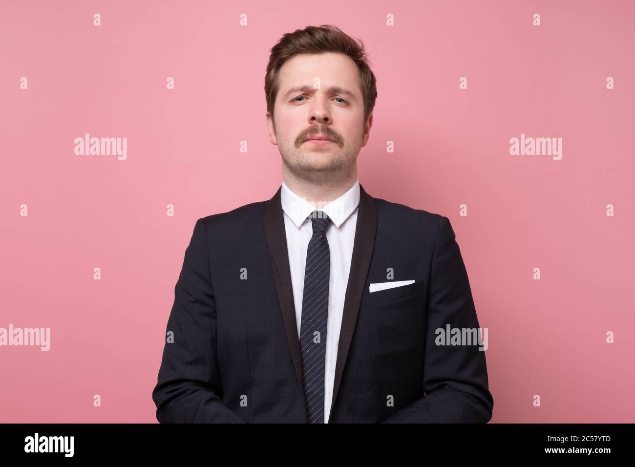 Handsome young man in suit looking at camera serious and confident. Stock Photo