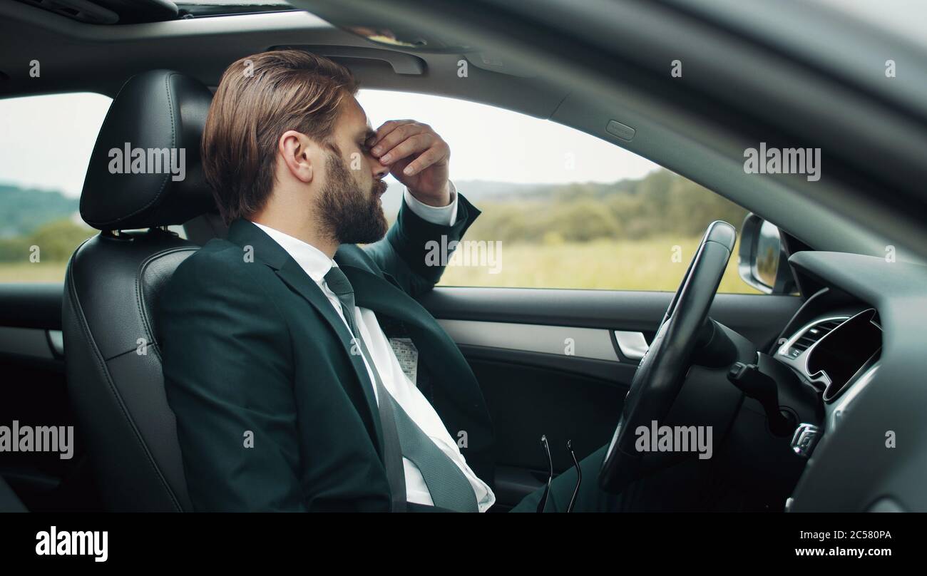 Tired businessman sitting driver's seat Stock Photo