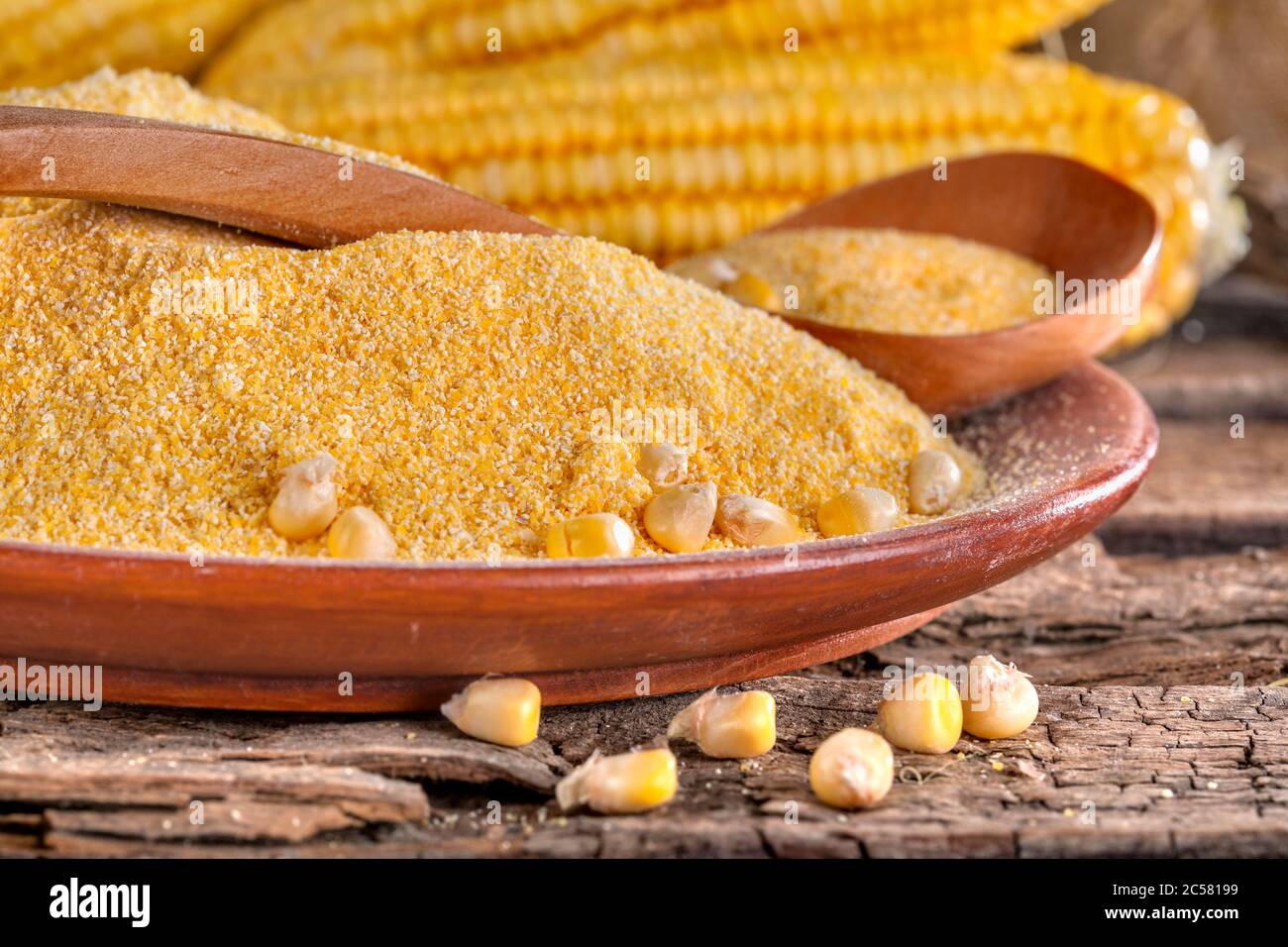 Corn grits polenta in a wooden bowl on an old wooden table. Detox and an antioxidant diet. The concept of healthy eating and lifestyle. Stock Photo