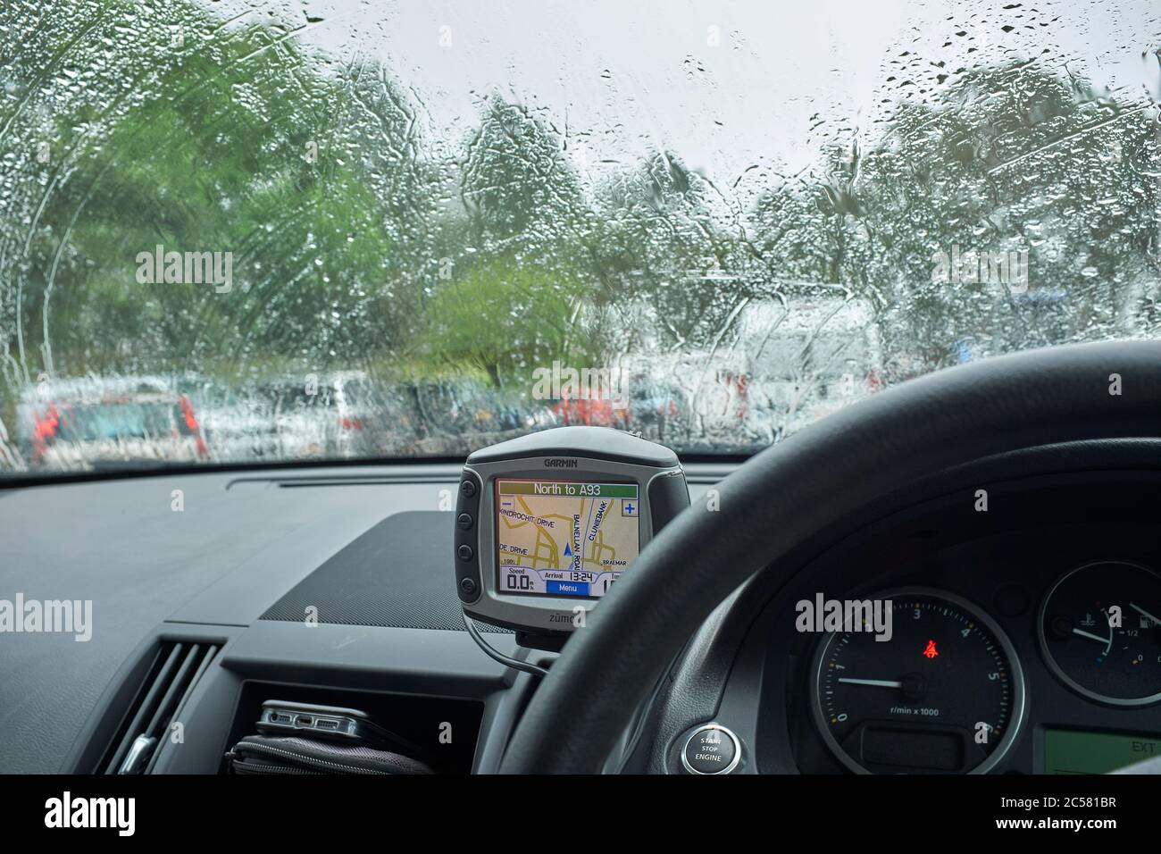Sheltering in the car during a heavy downpour in July in the centre of Braemar Stock Photo