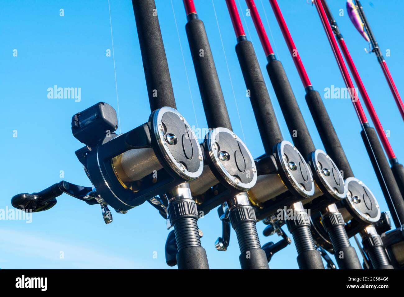 https://c8.alamy.com/comp/2C584G6/fishing-trolling-boat-rods-in-rod-holder-big-game-fishing-fishing-reels-and-rods-pattern-on-boat-sea-fishing-rods-and-reels-in-a-row-2C584G6.jpg