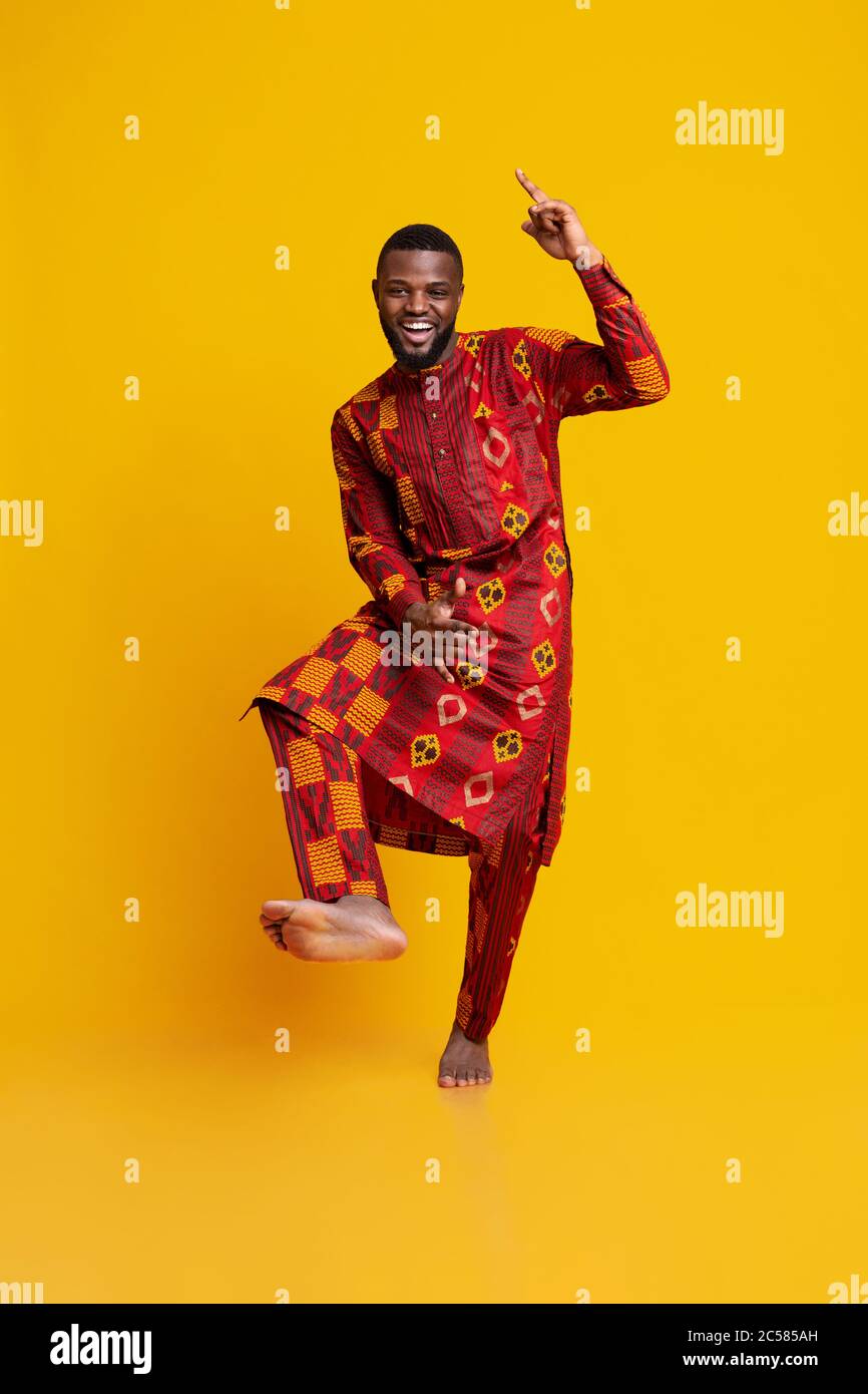 Cheery black guy having fun over yellow background Stock Photo