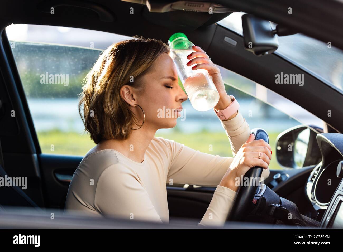 Exhausted woman driver feeling headache, sitting inside her car
