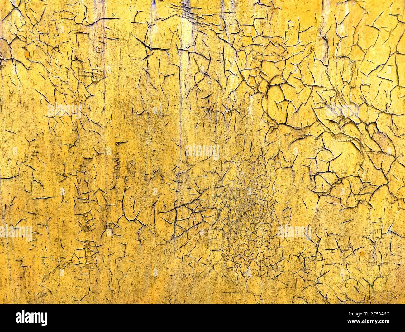 Corroded metal background. Rusted yellow painted metal wall. Rusty metal background with streaks of rust. Rust stains. The metal surface rusted spots. Stock Photo