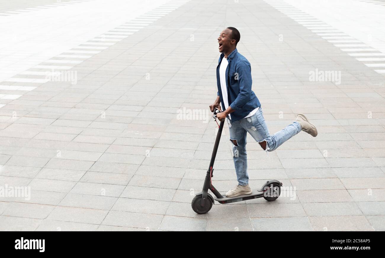 Guy having pleasant ride on electric kick scooter Stock Photo