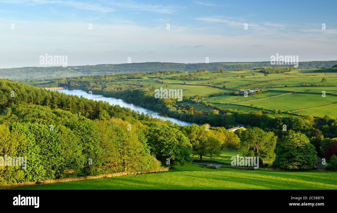 Long-distance picturesque sunny evening view (hillside woodland, green fields & pastures, sunlit reservoir - Washburn Valley, Yorkshire, England, UK. Stock Photo