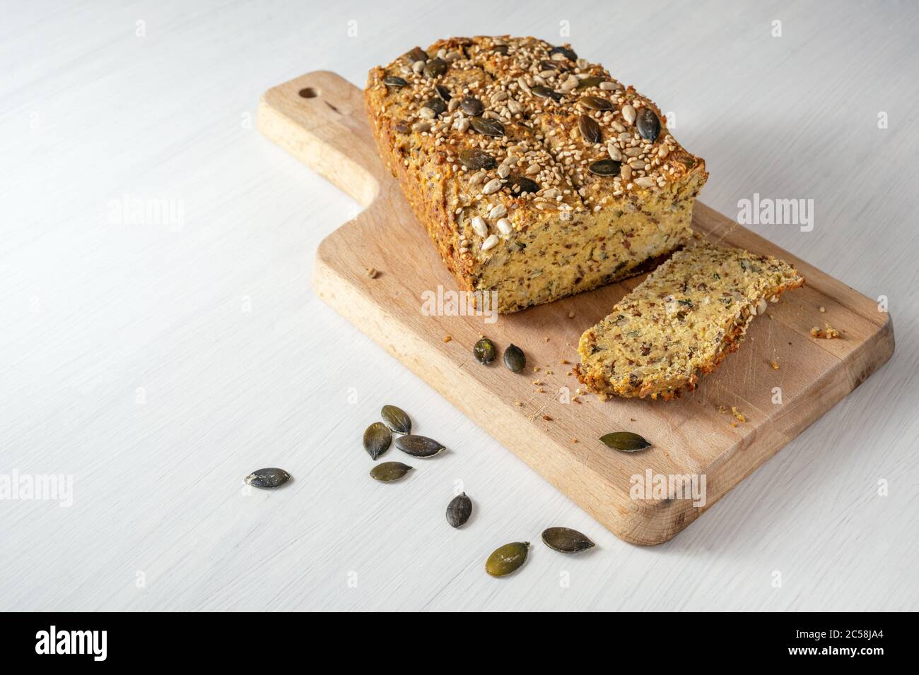 Protein bread from quark, oat bran, lupine flour, almond, pumpkin seeds and other healthy ingredients, baking for low carb or ketogenic diet, wooden c Stock Photo