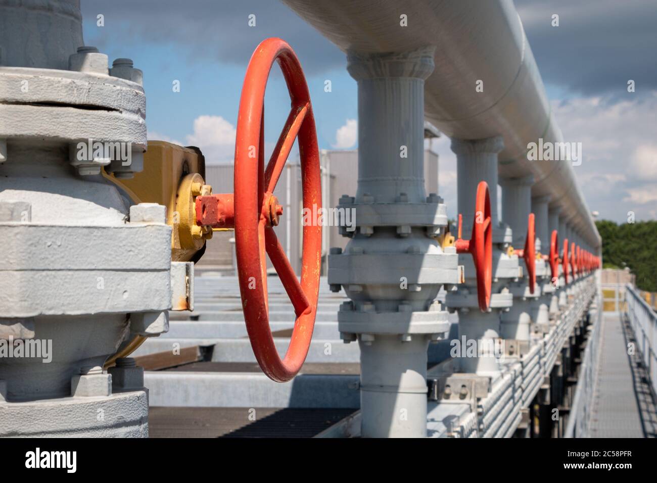 Red manual valves for opening or closing a pipe, also called hand valve in an industrial area Stock Photo