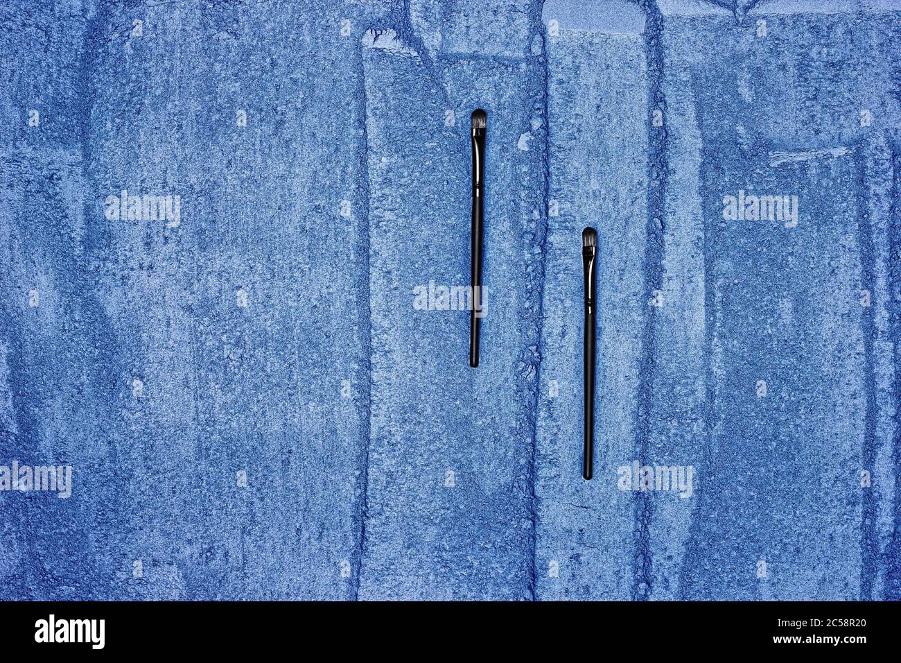 Makeup brushes on crushed blue compact eyeshadow. Eye shadow texture