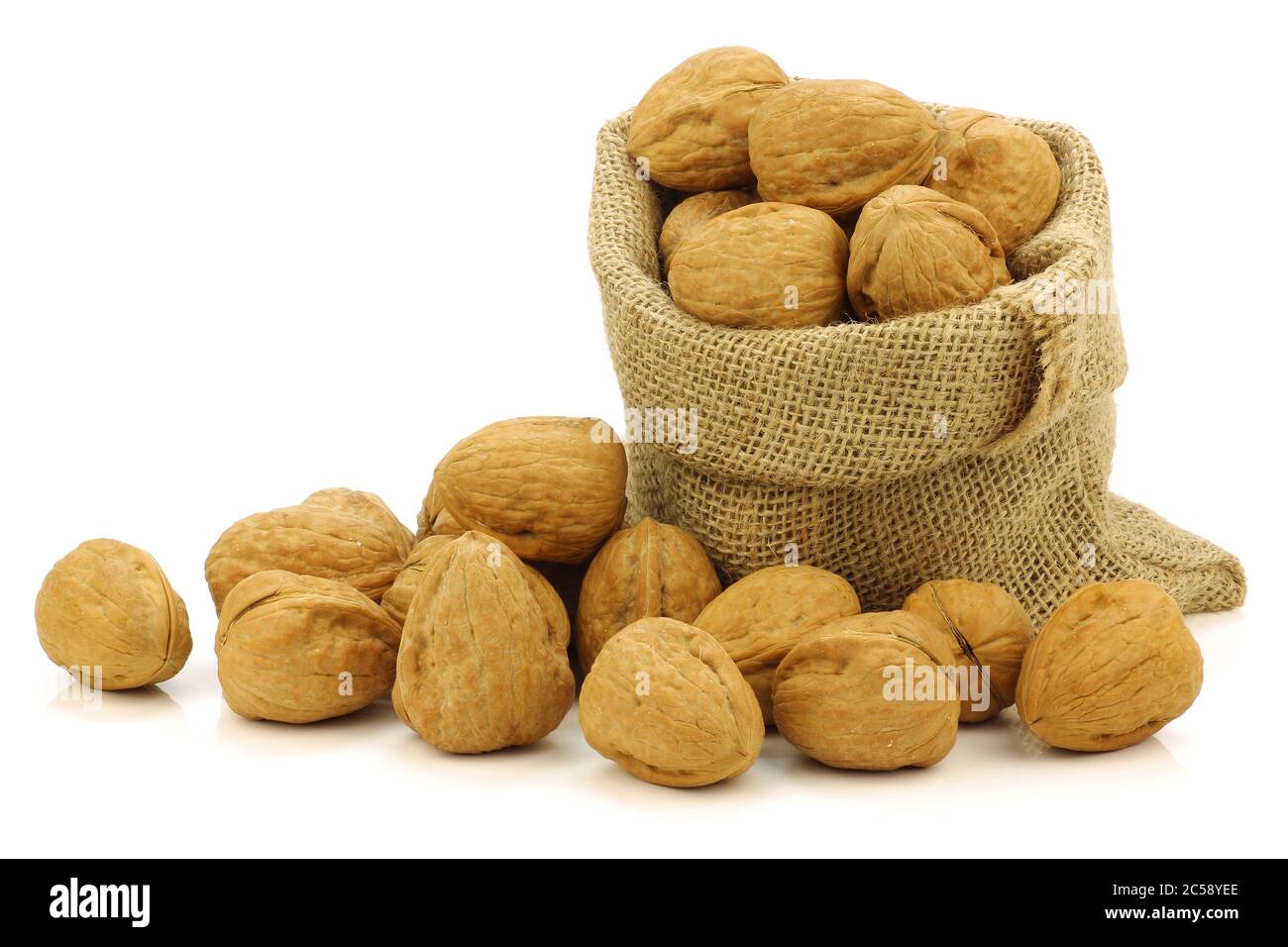 fresh walnuts in a burlap bag e on a white background Stock Photo