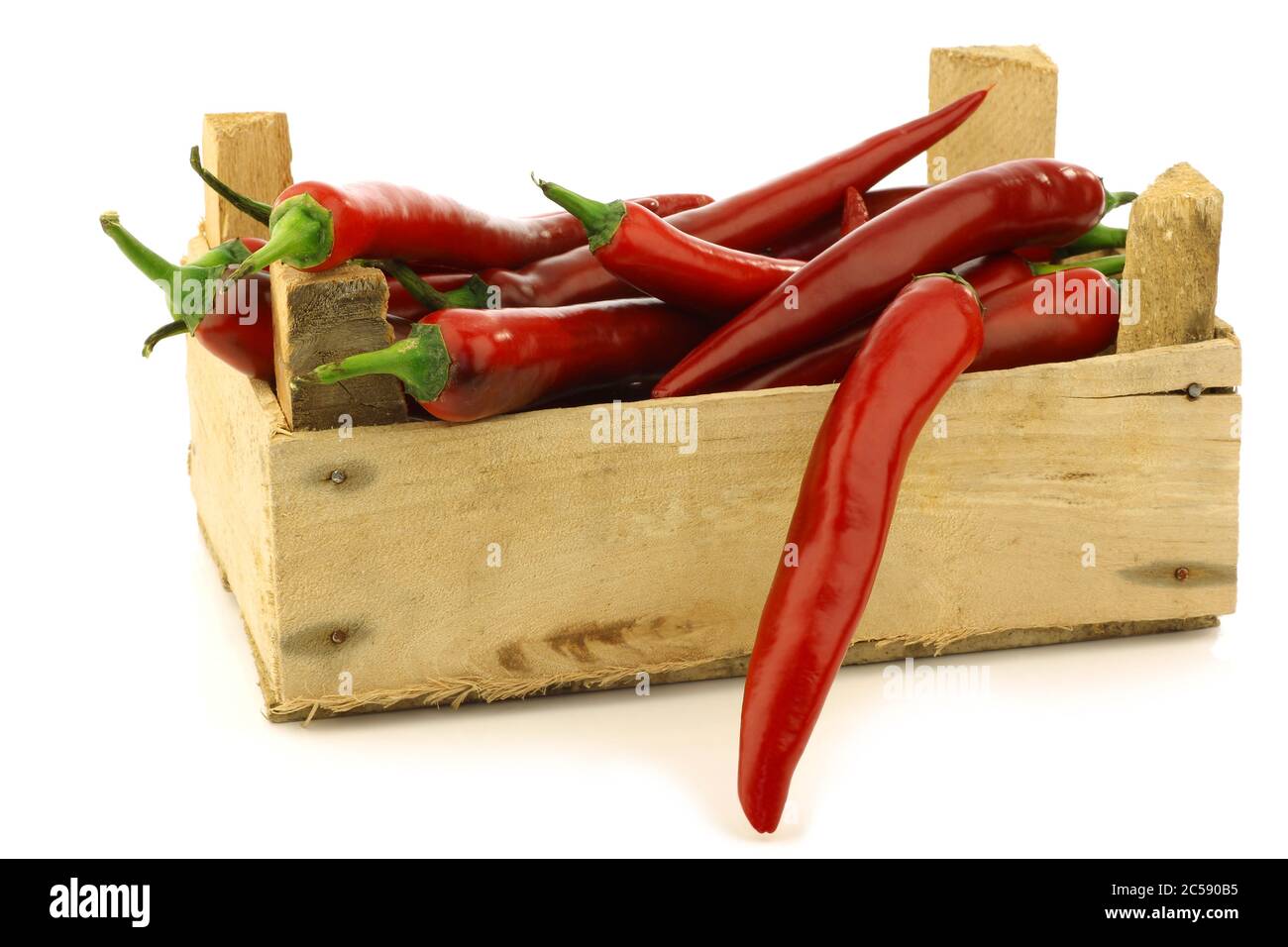 fresh red chili peppers in a wooden crate on a white background Stock ...