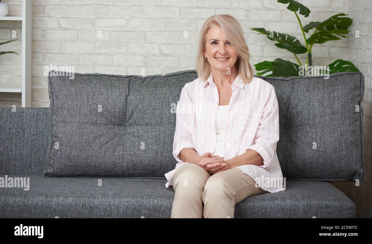 Beautiful 50 years old woman relaxing on sofa at home Stock Photo Alamy