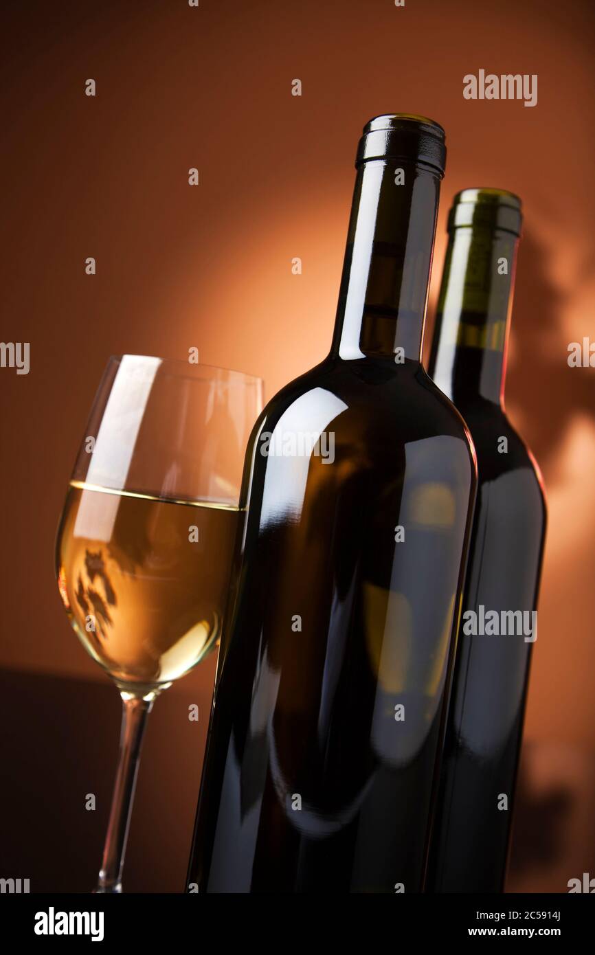 glass of white wine and two bottles, tilted view Stock Photo Alamy
