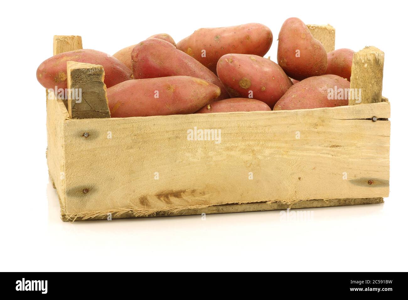 fresh roseval potatoes ina wooden box on a white background Stock Photo