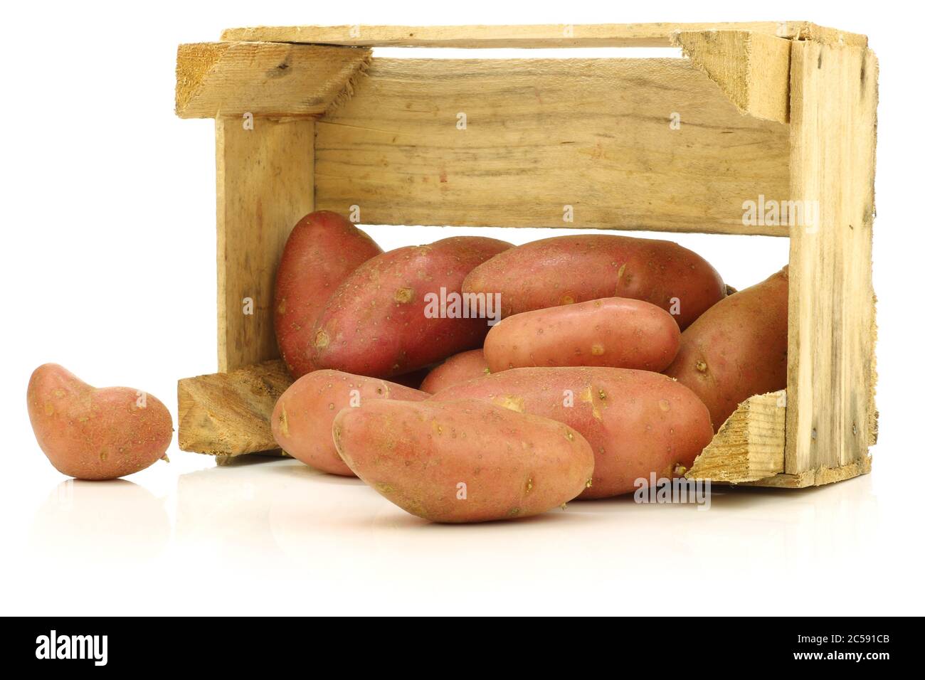 fresh roseval potatoes ina wooden box on a white background Stock Photo