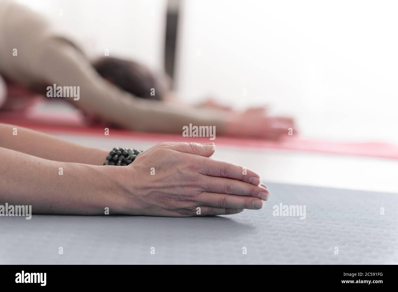 Close-up of feminine and masculine arms during meditation. Shashankasana position. Rabbit Pose. Seguence of Surya namaskar. Greeting to the Sun. How Stock Photo