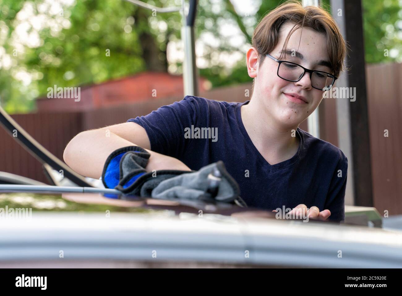 young guy washes a car with a rag Stock Photo